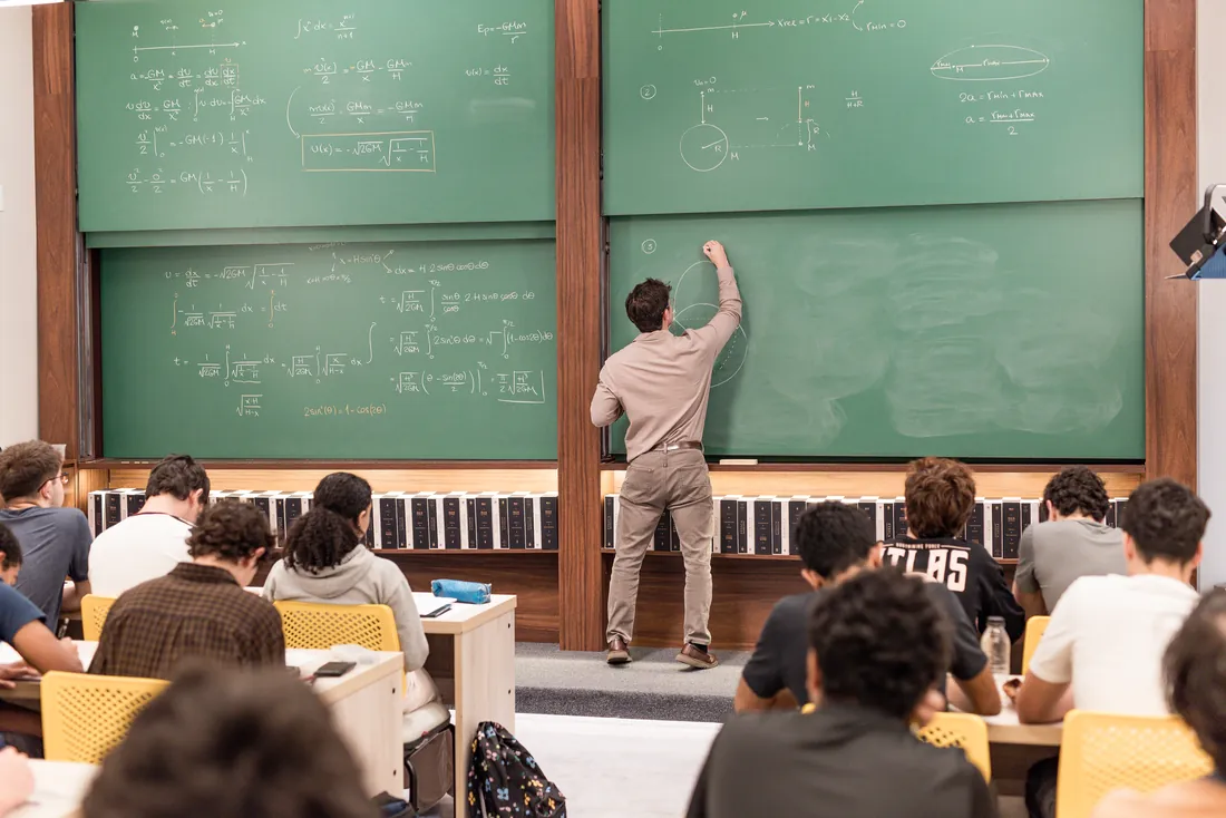 O Felipe escrevendo no quadro verde, com a turma acompanhando a aula