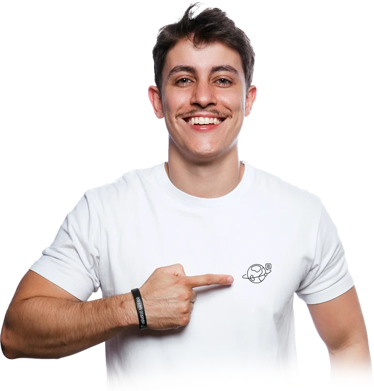 Felipe Guisoli, professor e fundador do Universo Narrado, de camisa branca, sorrindo e apontando para o logo no peito