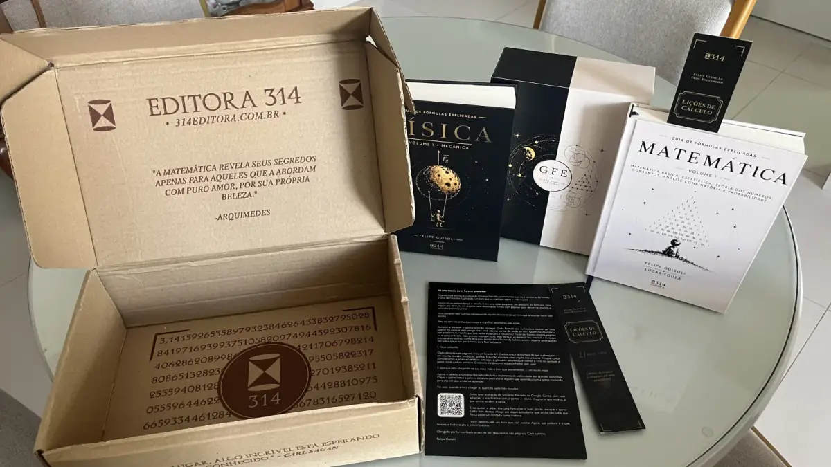 A caixa da Editora 314 aberta sobre a mesa de um leitor, com os dois volumes do Guia, o marcador e a carta