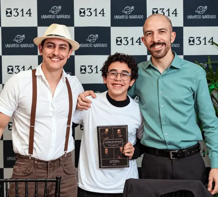 Felipe e o Engenheiro com um aluno segurando o livro Lições de Cálculo